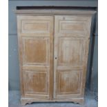 A George III pine wardrobe with flared reeded cornice, enclosed by a pair of triple panelled