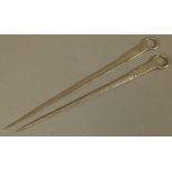 TWO GEORGE III SILVER MEAT SKEWERS with plain ring handles, one engraved with a crest and by William