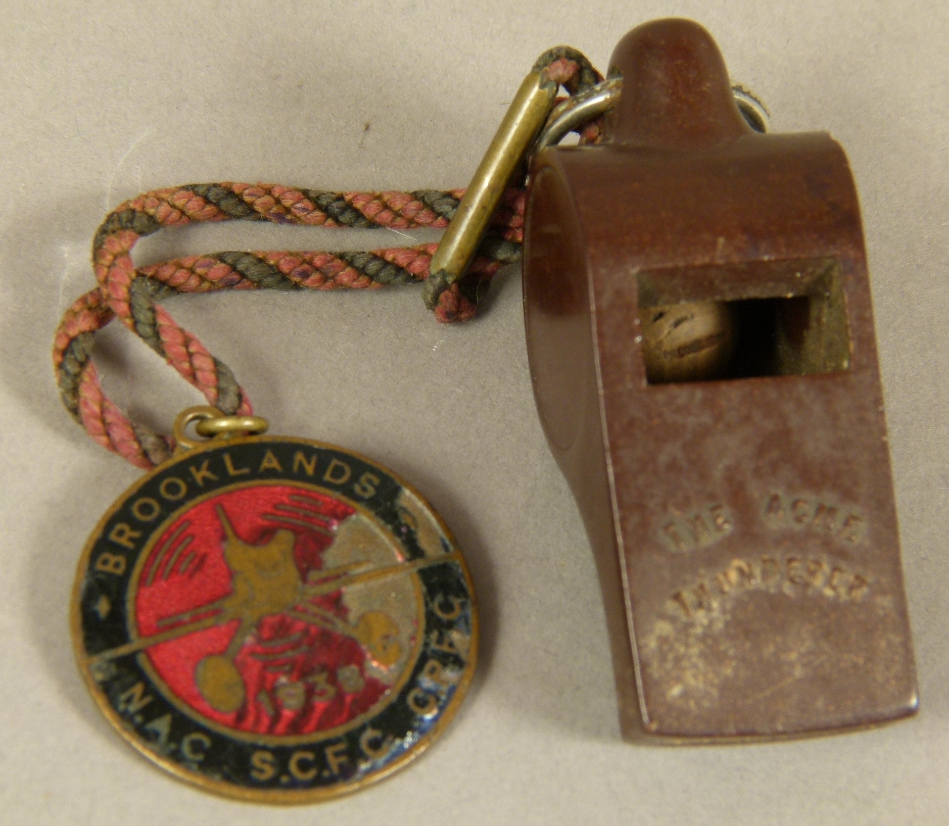 A BROOKLANDS BRASS AND ENAMEL FLYING MEDALLION, circular, worked with a plane on a red enamel - Image 2 of 2