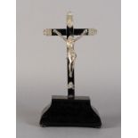 A FRENCH OR ITALIAN SILVER AND EBONISED WOOD CRUCIFIX, on a bombe-shaped stand with bun feet, 30.5cm