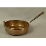 A LARGE COPPER PAN 19th century, circular, having a tapering hollow iron handle and copper loop