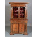 AN ITALIAN WALNUT CUPBOARD, having a flared and dentil cornice above a deep frieze and two iron