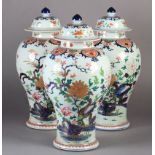 A SET OF THREE CHINESE EXPORT FAMILLE ROSE PORCELAIN VASES AND COVERS, Qianlong of baluster outline,