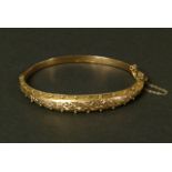 A VICTORIAN STIFF HINGED BANGLE in 9ct rose gold by Peyton Pepper Ltd, Birmingham 1898, tapered