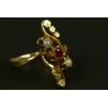 AN EARLY 20TH CENTURY GARNET AND SEED PEARL DRESS RING in 18ct gold, collet set within an open