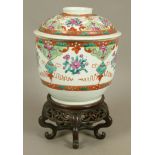 A CHINESE FAMILLE ROSE DECORATED JAR AND COVER alternately painted with flowers, leafage and