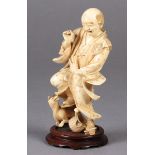 A JAPANESE IVORY OKIMONO OF A MAN, startled and frightened by a dog as it bares its teeth at him,