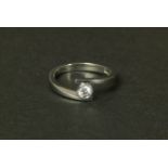 A SINGLE STONE DIAMOND RING IN PLATINUM, the brilliant cut stone collet set in a cross over band,