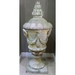 A VICTORIAN STYLE CONCRETE GARDEN URN AND COVER, the body cast with pair of ram masks and oak leaf