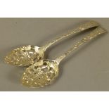 A PAIR OF GEORGE III SILVER TABLESPOONS with pierced, embossed and repousé decorated bowls of fruit,