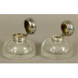 A PAIR OF GEORGE V SILVER LIDDED GLASS INKWELLS of domed circular form with honeycomb faceted