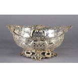 A VICTORIAN OVAL BASKET with foliate cast rim and pair of ribbon tied oval cast classical heads, the