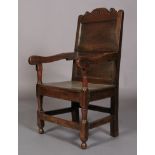 A LATE 17TH CENTURY OAK ARMCHAIR, having carved and pierced leaf and scroll cresting above two