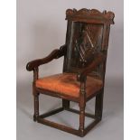 AN OAK ARMCHAIR in 17th century style, the carved top rail above a lozenge carved panel back, slab