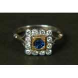 A SAPPHIRE AND DIAMOND CLUSTER RING, in 18ct yellow and white gold, the circular faceted sapphire