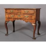 A GEORGE I WALNUT CROSSBANDED SIDE TABLE having two short and one long drawer, crossbanded and