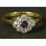 AN AMETHYST AND DIAMOND CLUSTER RING in 18ct gold and platinum c.1920 set to the centre with a