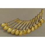 A SET OF TWELVE SILVER GILT .800 TEASPOONS of fiddle, thread and shell pattern, by Hessenberg,