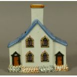 A 19TH CENTURY STAFFORDSHIRE PRATTWARE COTTAGE MONEY BOX, having four lancet-shaped windows