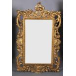 A GILTWOOD AND GESSO ROCOCO STYLE WALL MIRROR with ornate C and foliate scroll carved frame, gadroon