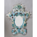 A VENETIAN BLUE AND CLEAR GLASS MIRROR, of rococo cartouche form, profusely applied with moulded