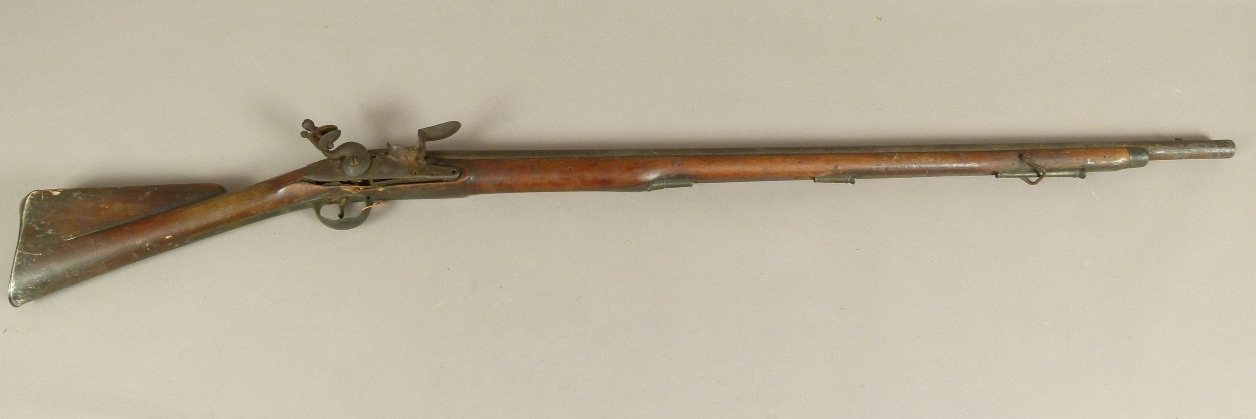 A LATE 18TH CENTURY FLINTLOCK MUSKET three quarter stocked with steel lock plate engraved REA, brass