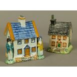 A 19TH CENTURY STAFFORDSHIRE PRATTWARE COTTAGE MONEY BOX of typical architecture flanked by a