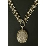 A VICTORIAN SILVER LOCKET AND COLLAR, the oval locket foliate engraved and hung from a double reeded