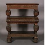 AN OAK THREE TIER BUFFET in mid 16th century style, the top above foliate carved frieze drawer,