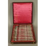 A SET OF TWELVE OYSTER FORKS, the prongs mounted in shell terminal, the handles embossed with