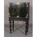 A 17TH CENTURY BLACK LACQUER CABINET ON STAND, the pair of doors highlighted with sprigs of oak