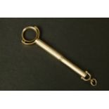 A CIGAR PIERCER IN 9CT GOLD by Dunhill London c.1949, with swivelling circular holder and spring