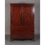A GEORGE III MAHOGANY CLOTHES PRESS with dental moulded cornice, above a pair of doors, four