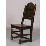 AN OAK DERBYSHIRE CHAIR 19th century the arched panel back carved with stylised flower heads and