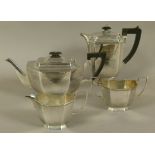 A GEORGE V SILVER FOUR PIECE TEA SERVICE of irregular octagonal form, with ebonised finials and