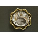 A Victorian swivelling brooch in pinchbeck set with dressed hair on white ceramic and contemporary