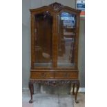 A reproduction burr walnut veneered display cabinet in Queen Anne style with shell and scroll carved