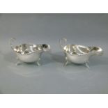 A pair of George VI silver sauceboats of conventional form with cast Celtic lips the flying C-scroll