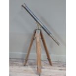 A reproduction brass telescope on brass and wooden tripod stand