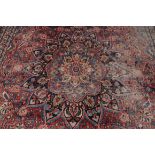 A Mashad carpet, North East Persia, the burgundy field with a blue floral star medallion to the