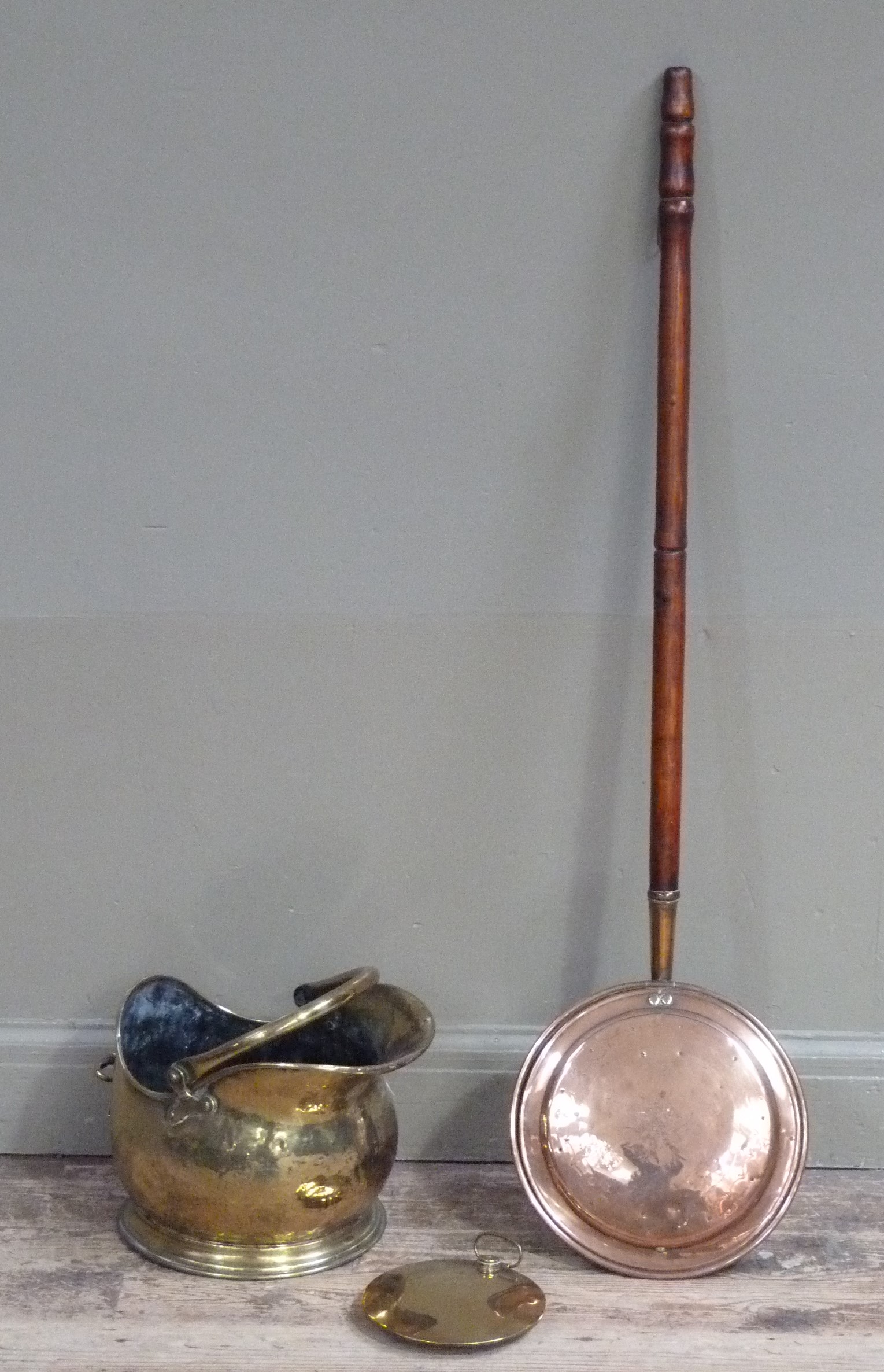 A Victorian copper warming pan, a brass coal scuttle and a brass hot water bottle