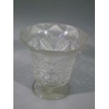 A large cut glass flower vase with flared rim and on short pedestal