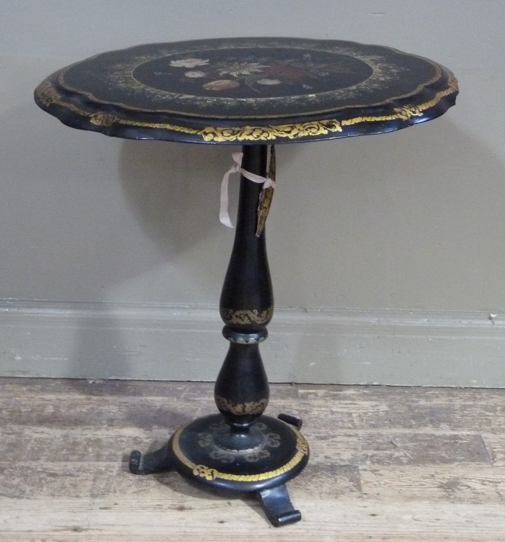 A Victorian black papier mache oval occasional table, the tilting top painted to the centre with a