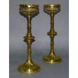 A pair of 19th century brass candlesticks on ring turned columns each with a bladed knop, raised