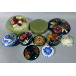 Ten Moorcroft lids of various glazes and patterns including Moorcroft Pansy, Orchid, etc