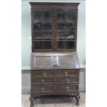 A 1920s oak and glazed bureau bookcase with blind fret work and moulding, the fall front fitted with