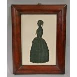 A silhouette cut out in black with gilt highlights, full portrait of a Victorian woman, laying