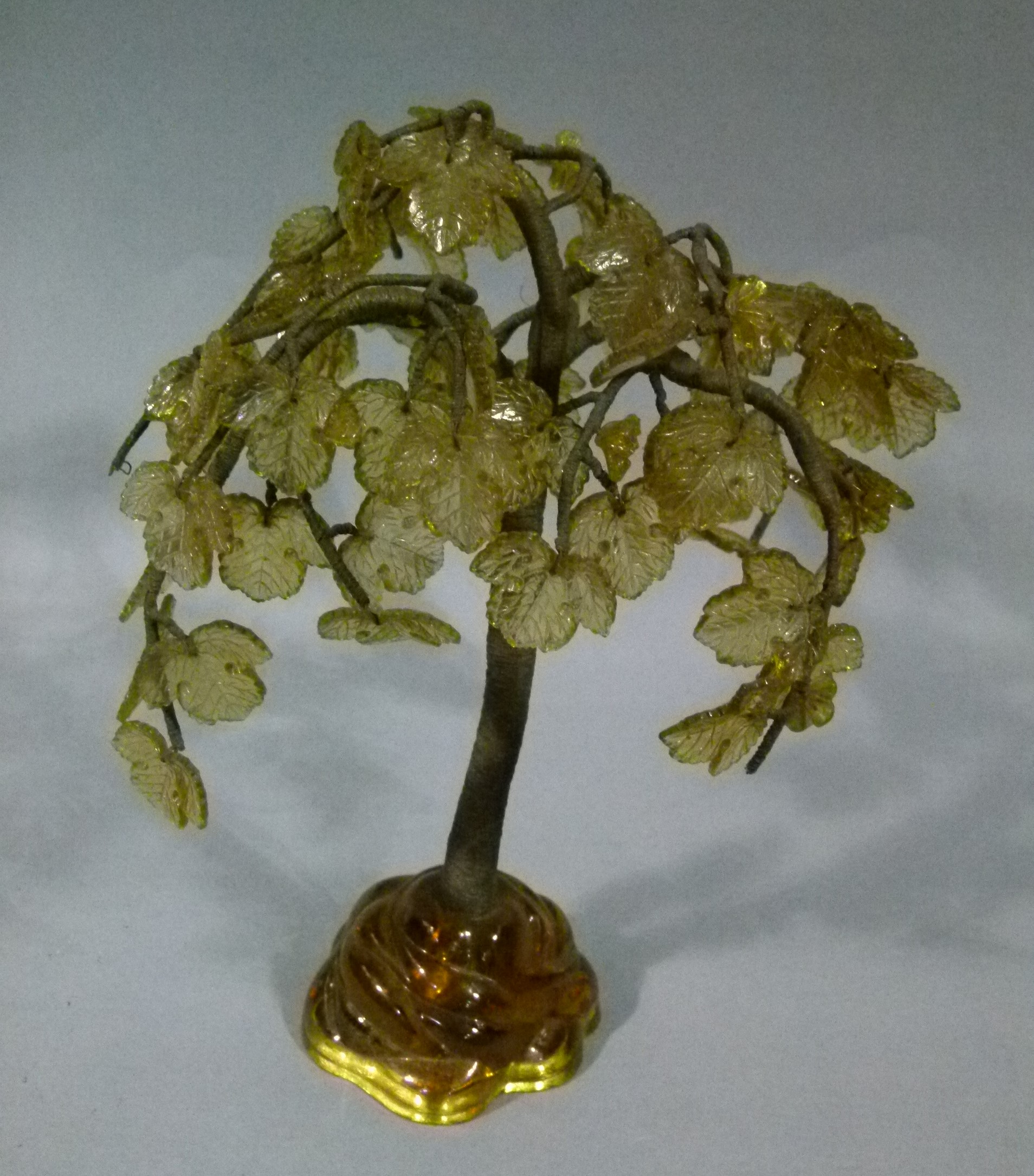 A glass and gilt metal weeping tree ornament on sculpted glass base