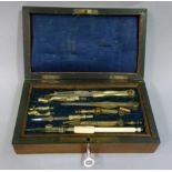 A late 19th/early 20th century faux rosewood box containing a selection of drawing instruments and