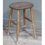 An ash and elm stool, the oval dished top above turned legs joined by stretchers, 55cm high